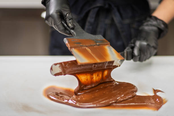 istock Confectioner in gloves makes chocolates in forms 1215753683