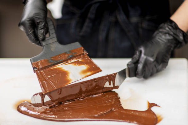 istock Confectioner in gloves makes chocolates in forms 1215754306