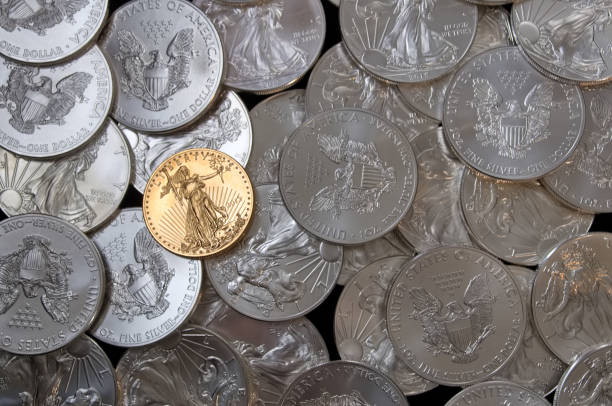 istock Many American Eagle silver coins with one gold coin 1215755427