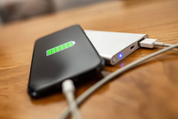 istock Close up smart phone charged on power bank 1215755886
