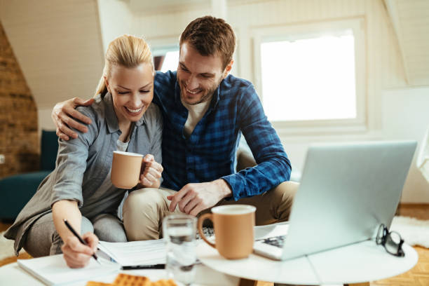 istock Happy couple writing notes while going through home finances during their coffee time. 1215755937