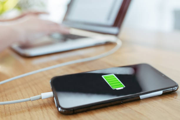 istock Close up smart phone charging with USB cable connected to laptop 1215756954