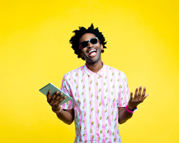 istock Happy nerdy man holding digital tablet, studio portrait 1215757077