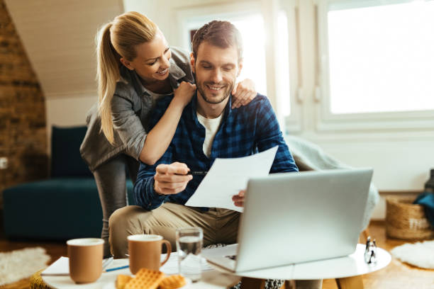 istock Young happy couple going through their finances at home. 1215757245