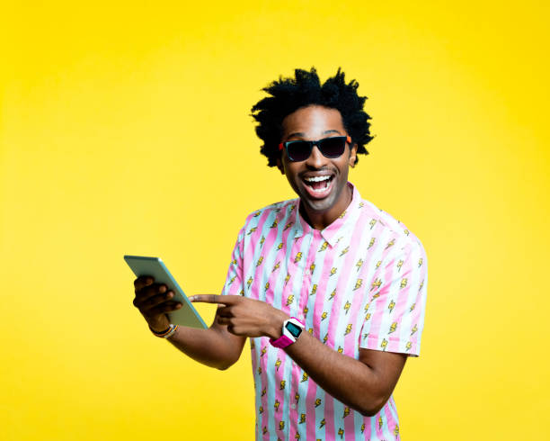 istock Happy nerdy man pointing at digital tablet, studio portrait 1215757600