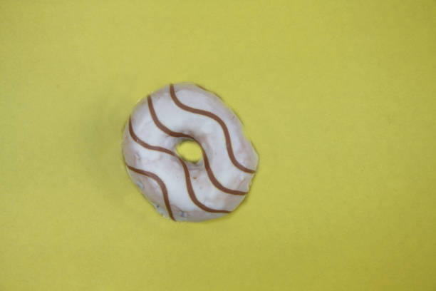 istock donut decorated with chocolate isolated on yellow background flat lay 1215757628