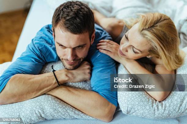 Young Displeased Couple With Relationship Difficulties In Bedroom Stock Photo - Download Image Now