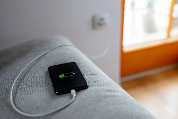 istock Smart phone charging,plugged into wall outlet 1215759465