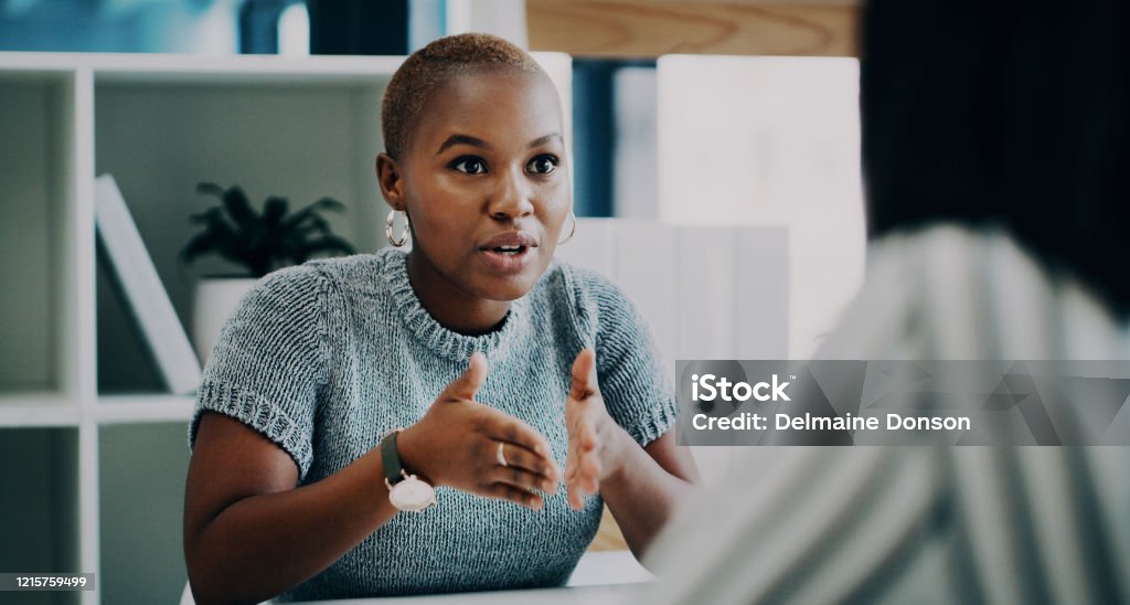 I has this amazing idea to pitch to you Shot of a young businesswoman having a discussion with a colleague in an office Discussion Stock Photo