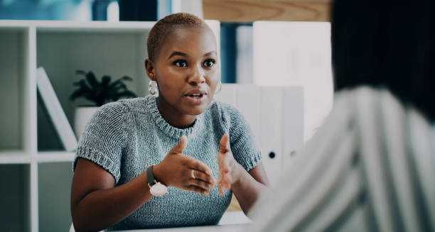 I has this amazing idea to pitch to you Shot of a young businesswoman having a discussion with a colleague in an office explaining stock pictures, royalty-free photos & images
