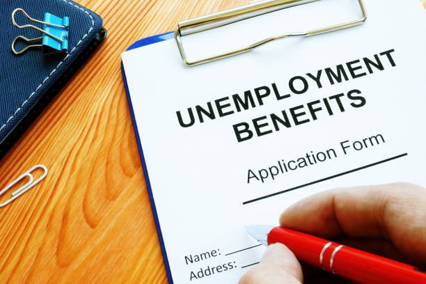 istock Man fills in Unemployment benefits application form. 1215761524