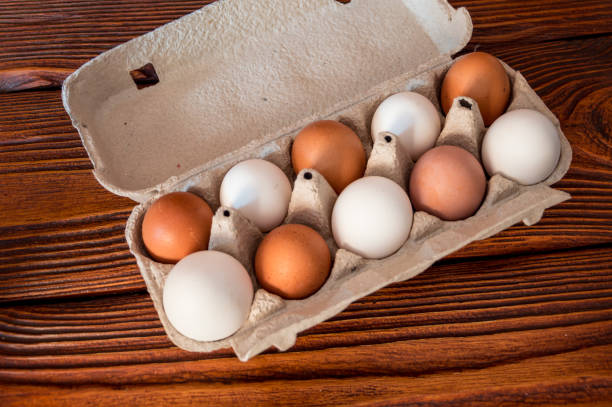 istock Chicken eggs in a tray on a wooden surface. 1215763450