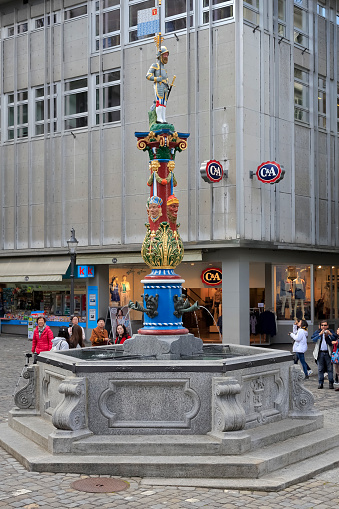 Lucerne, Switzerland - May 04, 2016: Fritschi Fountain in Gothic style with its colorful pillar is located in old town. A variety of fountains is a great tourist attraction in the city. The city of Lucerne is one of the countless wonderful places in Switzerland and a tourist attraction visited by many tourists from all over the world.