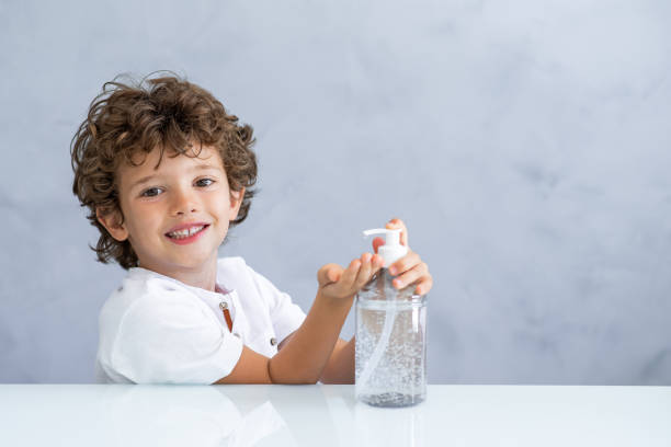 Child washing hands with alcohol gel