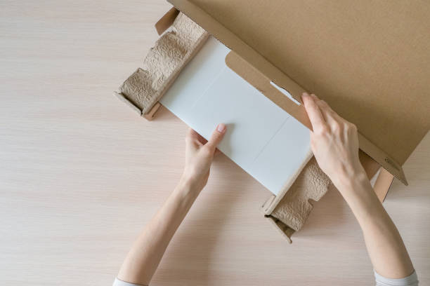 istock Unpacking a new laptop from a cardboard box. Hands open the box. Unpacking the received parcel 1215766850