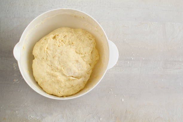 istock Raw dough in a white plastic plate on the table. Preparation for cooking. Top view 1215768214