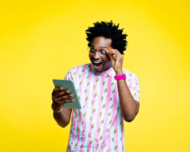 istock Surprised nerdy man reading good news on digital tablet 1215768328