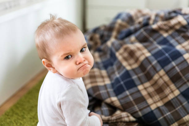 Offended angry upset kid sitting on the floor Offended angry upset kid sitting on the floor sulking stock pictures, royalty-free photos & images