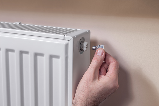 Venting the radiator. The man's hand holds a special key which he inserts into the vent valve .