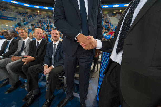 istock Businessmen shaking hands in stadium 1215776248