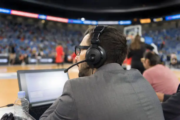 Basketball commentator wearing headphones using laptops in Arena Stozice, Ljubljana, Slovenia.