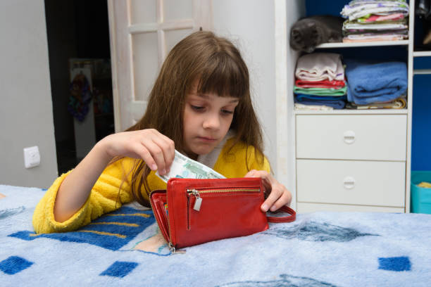 The girl opened her mothers wallet and pulls out a thousand-ruble note