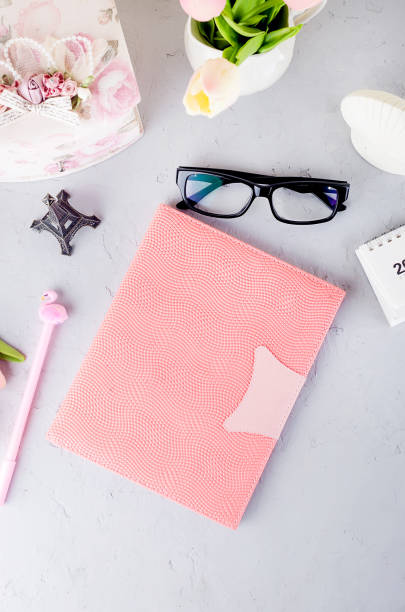 istock Feminine styled work place with tulips, eyeglass and notebook. 1215778253