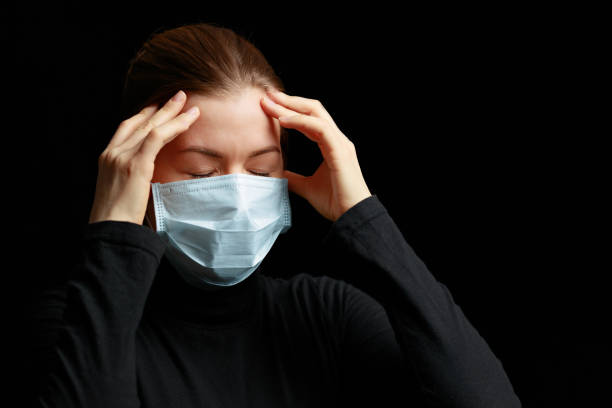 istock The woman with the mask has a headache. 1215781738