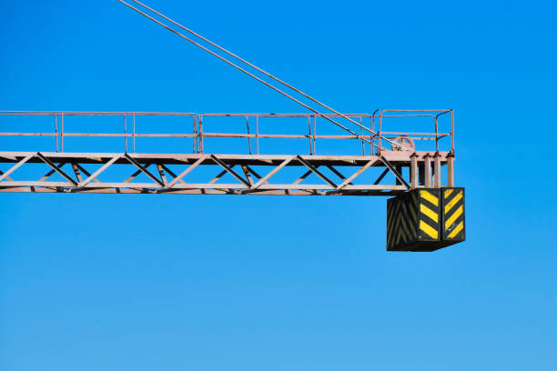 istock construction crane counterweight. High building construction site. Big industrial tower crane with blue sky amd cityscape on background. Concrete plates weight balance. Counterweight. Aerial drone view. Metropolis city development 1215782617