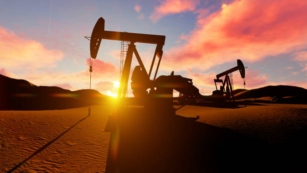 Oil pumps in the desrt over dusk sun. stock photo