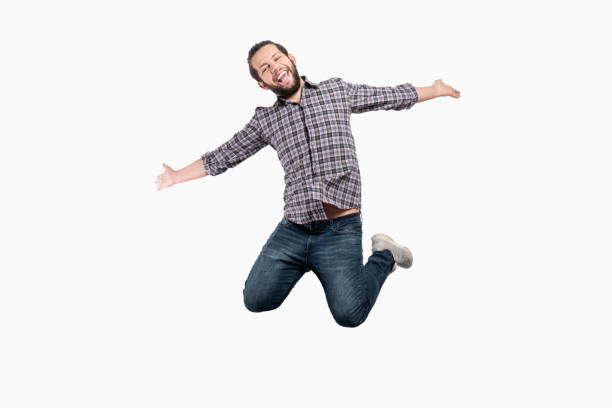 Portrait of laughing young man jumping on white background. Horizontal composition. Studio shot.