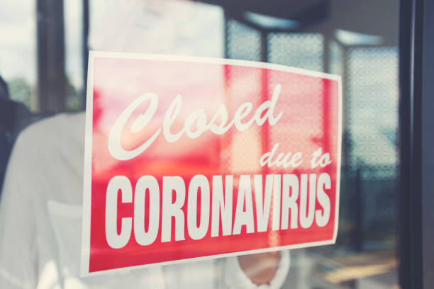istock Store owner putting up a closed sign in the window 1215786320