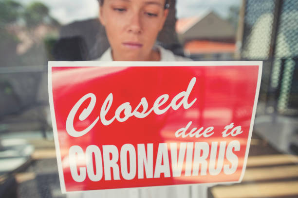 istock Store owner putting up a closed sign in the window 1215786328