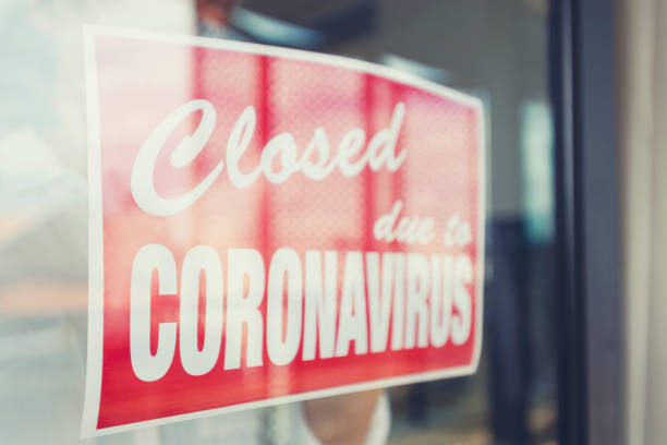 istock Store owner putting up a closed sign in the window 1215786341