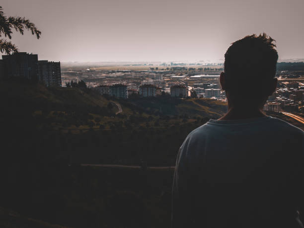 istock A man between the mysterious city and the forest. 1215788179