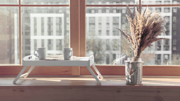istock Two white mugs on Serving table with flowers vase on window sill 1215789489
