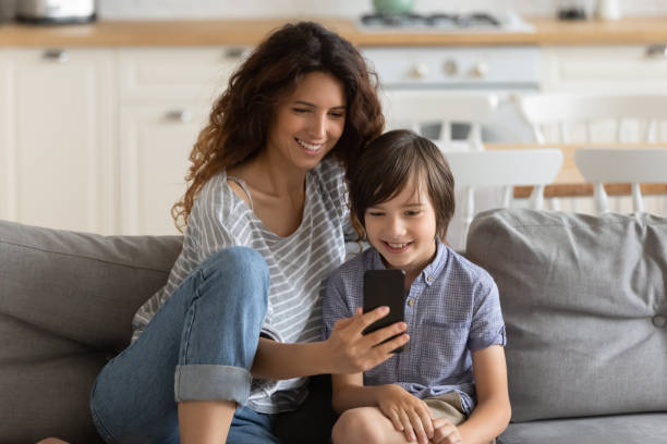 istock Happy mom have fun using smartphone with little son 1215789546