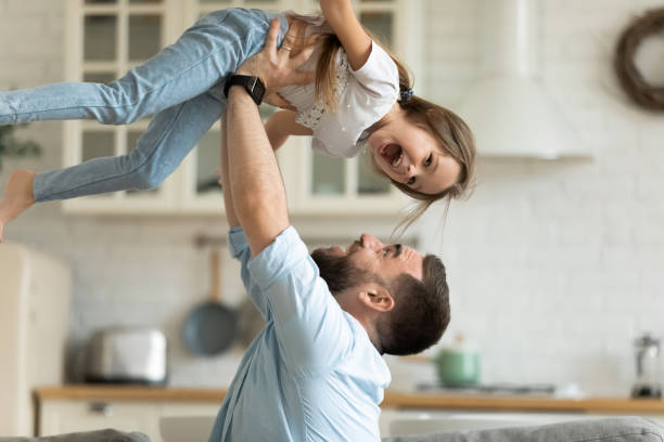 istock Overjoyed father playing with little daughter at home 1215789552
