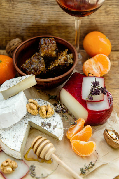 istock Rustic cheese platter with camembert, brie, gouda on wooden table, 1215790602