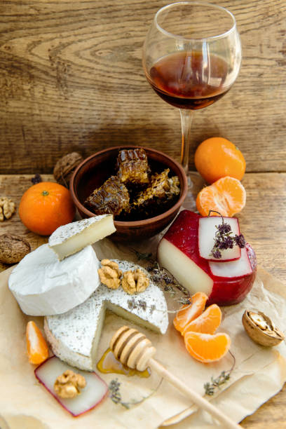 istock Rustic cheese platter with camembert, brie, gouda on wooden table, 1215790723