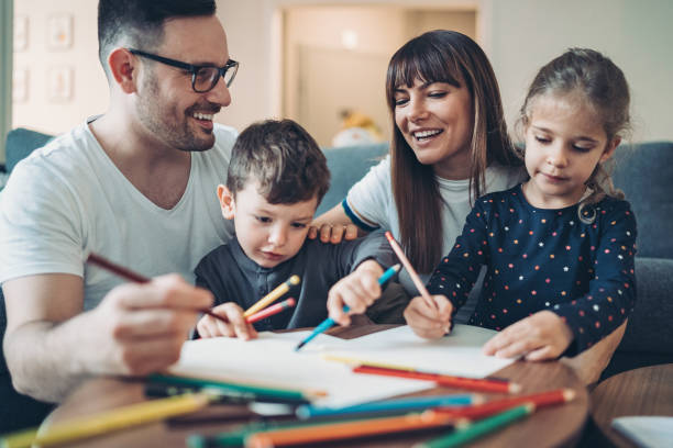 Parents and children coloring pages together Two parents and a little boy drawing and writing together stay at home saying stock pictures, royalty-free photos & images
