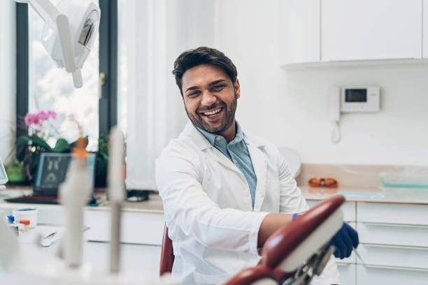 улыбающийся дантист в своем кабинете - dentist asian ethnicity portrait male стоковые фото и изображения