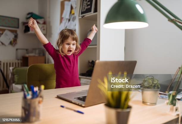 Ecstatic Three Year Old Girl Celebrating Winning On Video Game On Laptop Stock Photo - Download Image Now
