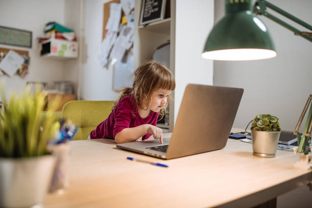 istock Three year old girl using internet on parent's laptop 1215792079