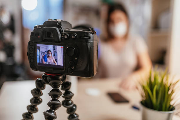 istock Social media tutorial with vlogger showing how to use protective gloves against Coronavirus 1215792131