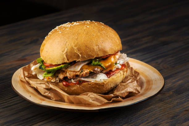 istock Appetizing hamburger with meat and vegetables on food paper 1215792309