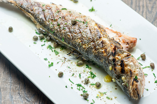 Branzino, whole grilled sea brim. Classic ethnic regional Greek  seafood favorite. Whole fish, grilled with skin in, served with lemon potatoes lemons Italian parsley and capers.