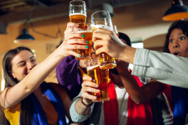 istock Sport fans cheering at bar, pub and drinking beer while championship, competition is going 1215793708