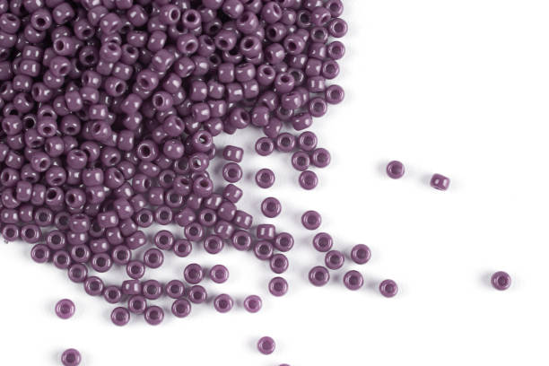 istock A scattering of purple beads on a white isolated background 1215795161