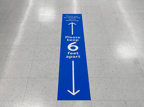 Señal de piso de distanciamiento social que advierte sobre la distancia segura entre personas de 6 pies. Medida de salud pública para prevenir la propagación de nuevas infecciones por el virus corona Covid-19. photo